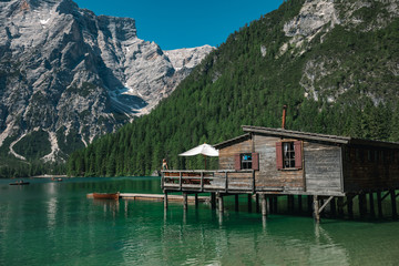 Fototapeta na wymiar Girl and view of well-known tyrolean lake lago di Braies Dolomites Italy.Travel hiker on Lake Braies (Lago di Braies) in Dolomites Mountains, Italy. Hiking travel and adventure