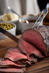 slicing eye of round roasted beef with knife