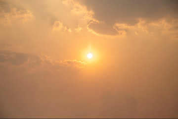 Sunset on the sky with clouds. The sun is in the middle of the picture. The sun in summer are feeling hot.