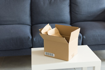 Opened cardboard over modern interior. Paper parcel opened indoors. Online shopping concept.