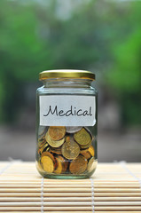 Coins in bottle with label Medical - financial concept