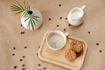 black coffee with milk and cookies on a wooden tray