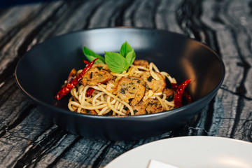 Dried Spaghetti Chili and Northern Thai Sausage Recipe (Sai Ua) served in black plate with white plate and cutlery.
