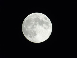 An amazing photography of the full moon over the city of Genova by night with a great clear sky in background and some stars