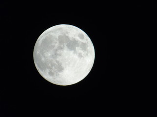 An amazing photography of the full moon over the city of Genova by night with a great clear sky in background and some stars