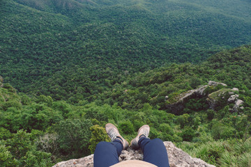 Fototapeta na wymiar top view of men sitting on cliff against mountain and tree