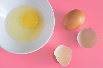 chicken eggs, white plate with chicken egg on a pink background, creative minimal concept.