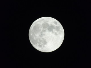 An amazing photography of the full moon over the city of Genova by night with a great clear sky in background and some stars