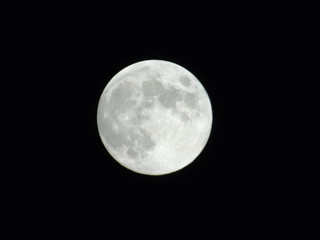 An amazing photography of the full moon over the city of Genova by night with a great clear sky in background and some stars