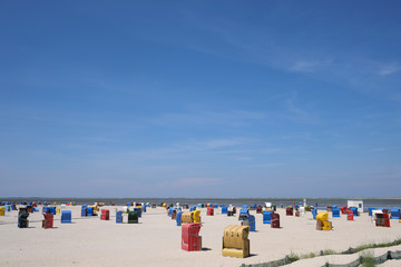 Panorama mit Strandkörben und Sandstrand und blauer Himmel im Urlaub an der Nordseeküste - Stockfoto