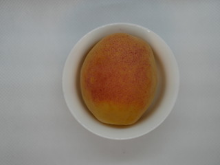 one ripe apricot in a small white porcelain plate on a white background. Natural vitamin. Healthy food. vegetarian food.