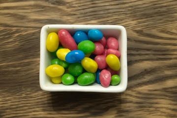 Multicolored round candy lying on the burlap. Multi-colored candies dragee.