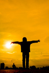 Silhouette of Girl Raising Her Hands or Open arms when sun going down