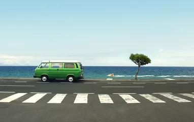 Poster Im Rahmen Photo of a green van on the road and sea © vali_111