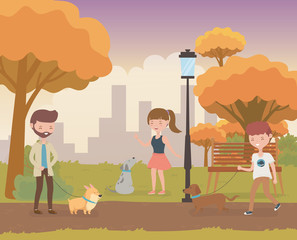 Fototapeta premium young people with cute little dogs mascots in the field