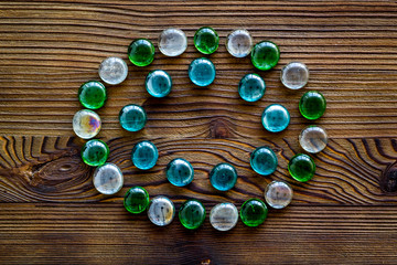 Shiny glass stones for decoration, creativity and craft on wooden background top view