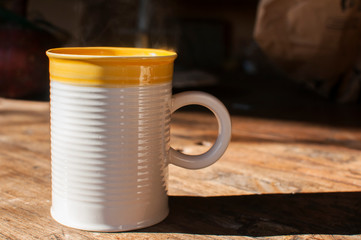 Ceramic tea mug closeup on wooden board surface