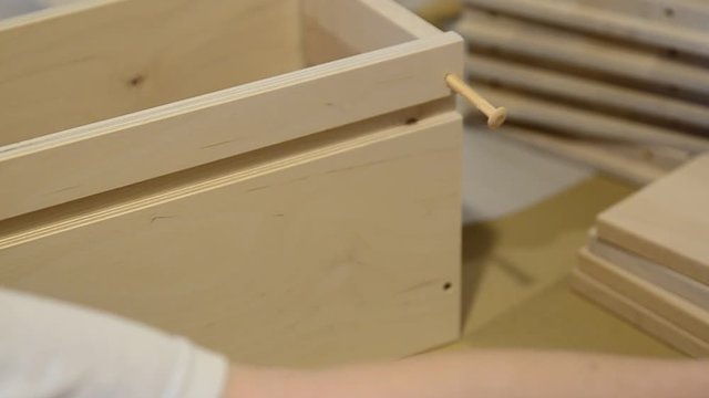 Turin, Piedmont, Italy. July 2019. Assembly of an Ikea furniture drawer. A Caucasian woman positions the elements of the drawer.