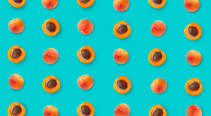 Top view of colorful fruit pattern of ripe apricots on blue background