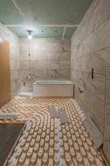 Sanierung eines Badezimmers mit Fliesen, Wanne und einer Fußbodenheizung