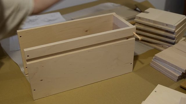 Turin, Piedmont, Italy. July 2019. Assembly of an Ikea furniture drawer. A Caucasian woman positions the elements of the drawer.