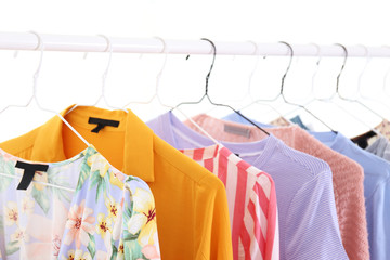 Women's hip clothing store interior concept. Row of different colorful female clothes hanging on rack in hipster fashion show room in shopping mall. Background, copy space for text.