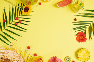 Fruits flowers cold juice and leaves of palm on yellow background