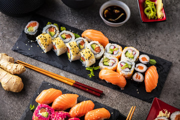 Sushi Set sashimi and sushi rolls served on stone slate