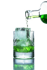 on a white background with a reflection is a glass glass glass filled with ice, it flows from a glass bottle of green lemonade (drink)
