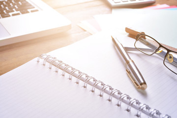 Notebook with calculator, keyboard and pen on table