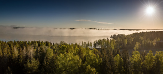 Naklejka na ściany i meble Sonnenaufgang an einem See in Schweden mit Nebel