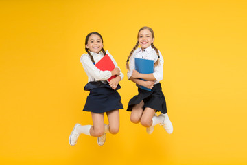 Fototapeta na wymiar funny education. little girls in school uniform. cheerful classmates with workbook. kids learning grammar. back to school. dictionary notebook. Get information. reading story. childrens literature