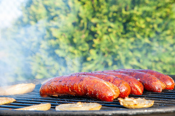 sausages are baking on the grill on a sunny summer day