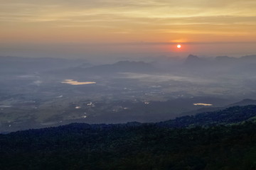 Mountain view morning of top hill around with soft fog and yellow sun light in the sky background, sunrise at Nok Aen Cliff, Phu Krakueng National Park, Loei, Thailand.