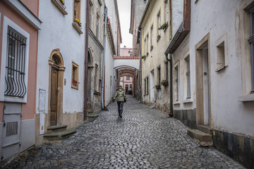 woman walking by small perast streets in old city in fall