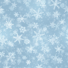 Christmas seamless pattern of complex blurred and clear falling snowflakes in light blue colors with bokeh effect