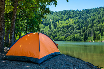 Camping tent at scenic campsite on a lake