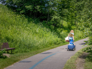 woman pulling wagon with kids on paved bike path