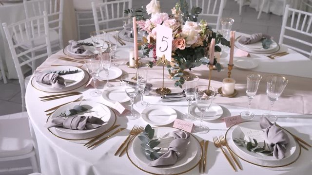 Wedding table decorations for guests in modern style, flower arrangement with roses and eucalyptus, pastel colors