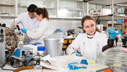 Woman lab technician writing report on chemical experiments