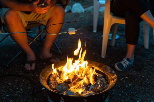 A Family around a camp fire roasting marshmallows
