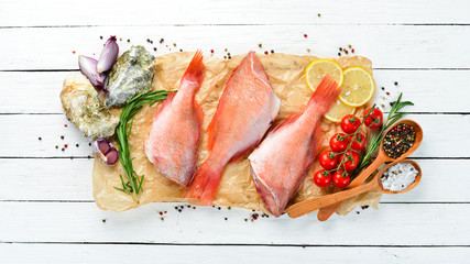 Fish is a sea snapper with lemon and rosemary. On a white background. Top view. Free space for your text.