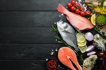Seafood on a black wooden background. Banner Top view. Free space for your text.