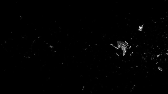 Super slow motion of shattered glass on black background. Filmed on high speed cinema camera, 1000 fps.
