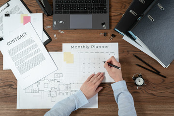 Woman working behind wooden table in office