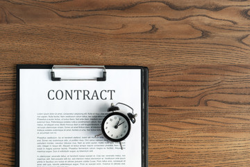 Documents and contract on wooden table in office