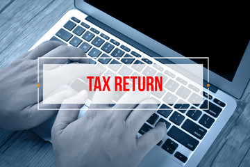 Hand Typing on keyboard with text TAX RETURN