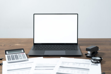 Modern laptop and documents on wooden table