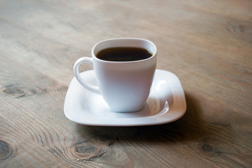 cup of coffee on wooden background. Beautiful white cup, stylish toning, place for text. Cup of black tea on wooden background. cheerful morning concept