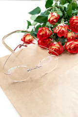 Women's glasses on white background with roses. Optics store, protect your eyes. Place for text.
